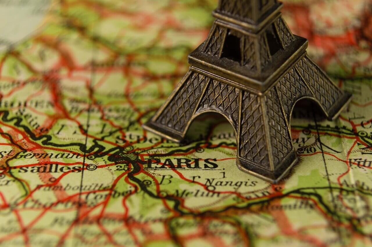Gold Eiffel tower model on top a map of Paris