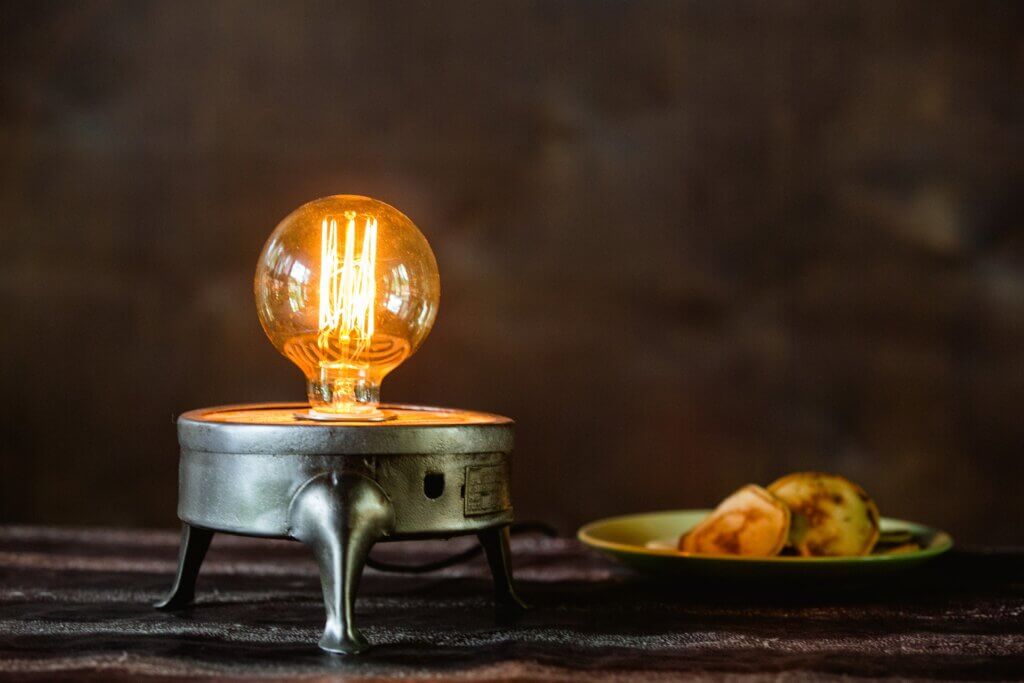 A custom made, single-bulb lamp on a table.