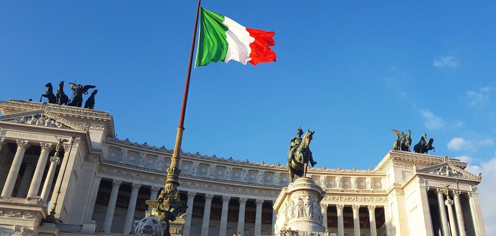 Italian flag waving in in front of a monument in Rome